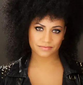 A woman with big hair and a black jacket.