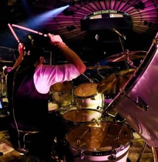 A man playing drums in front of a crowd.