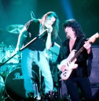 A man and woman playing guitar on stage.