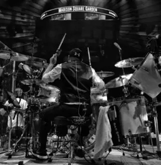 A man sitting on top of a drum set.