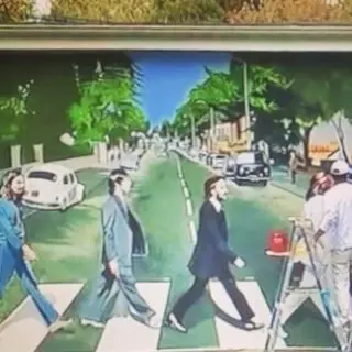 A mural of the beatles crossing the street.