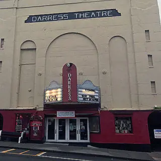 A darress theatre with a red door and white lettering.