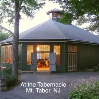 A green building with a large open door.