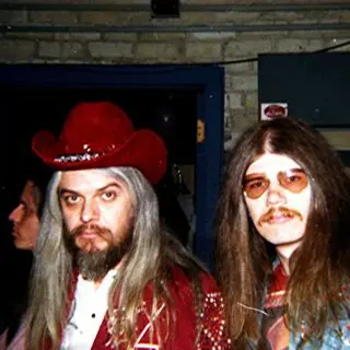 Two men in costumes are posing for a picture.