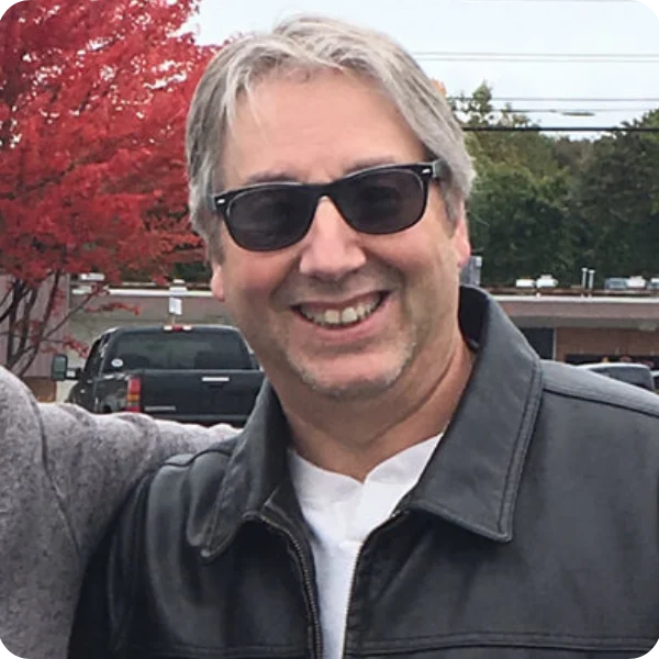 A man with sunglasses and a leather jacket.