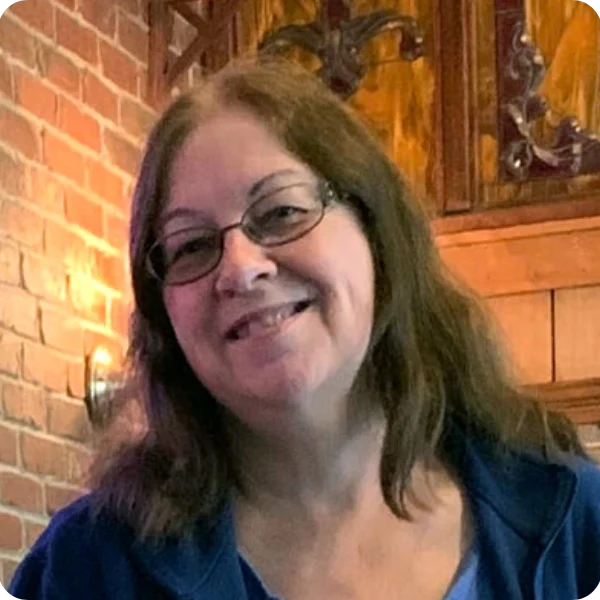 A woman with glasses smiling for the camera.